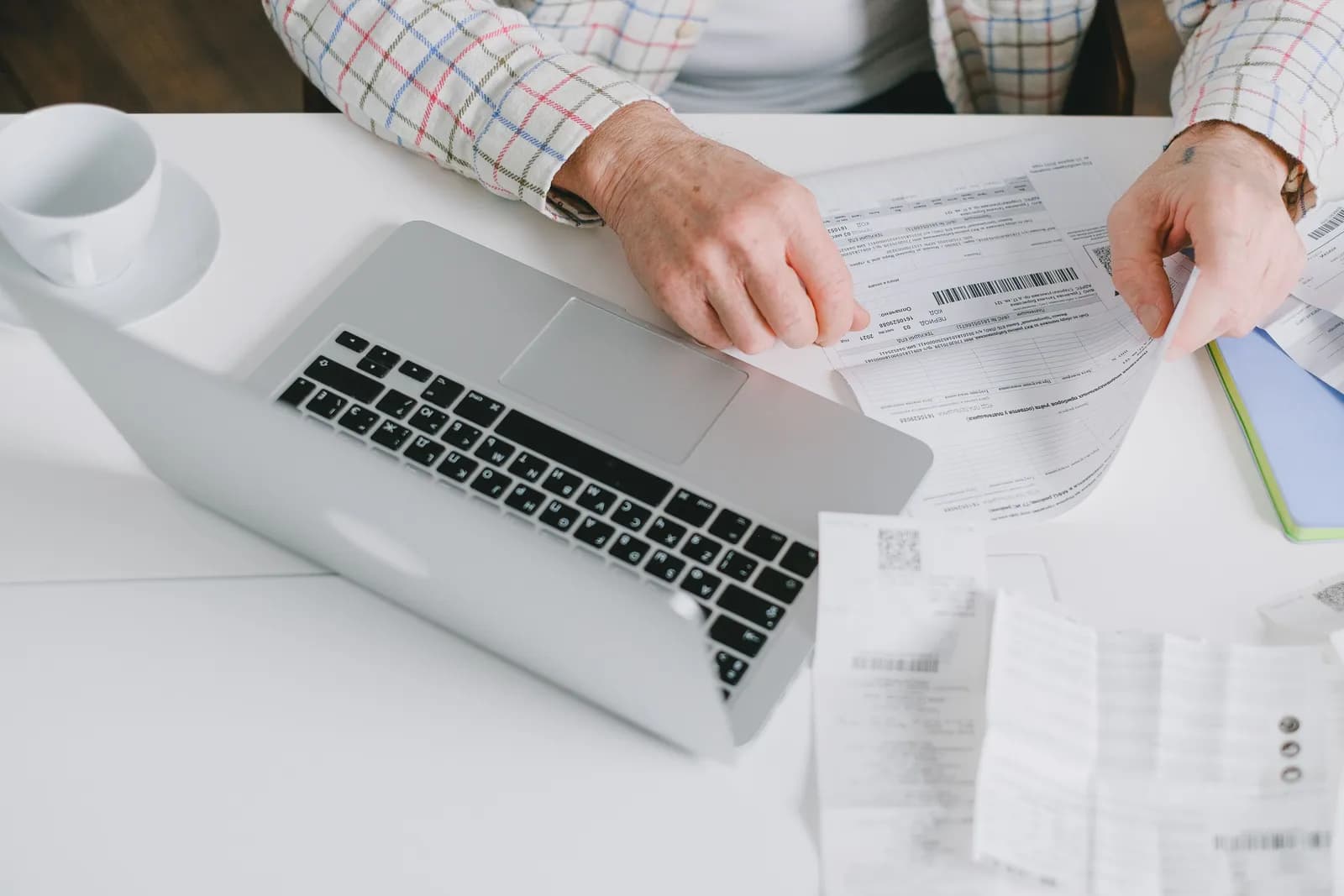 Checking freight invoices and receipts against costs on a laptop Checking freight invoices and receipts against costs on a laptop